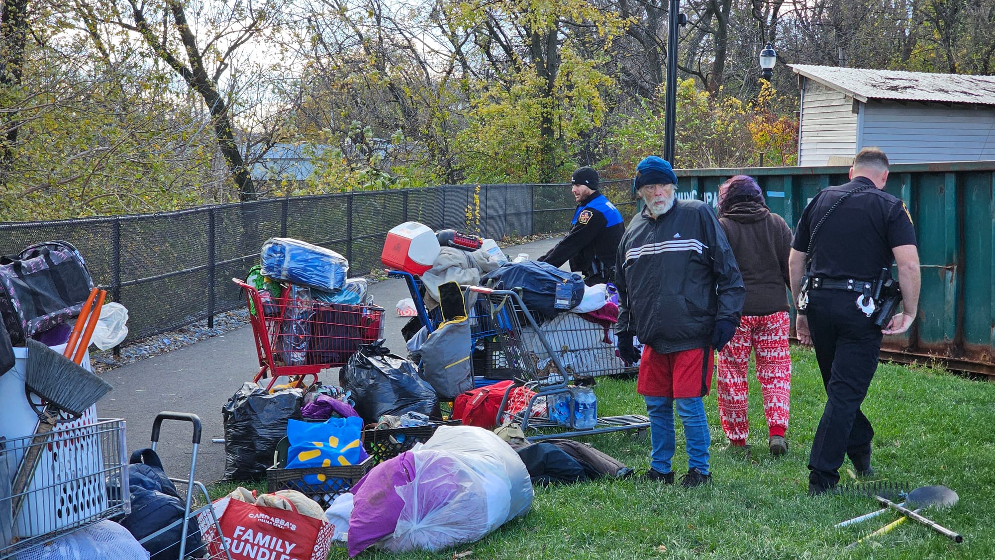 Allentown police officers pull homeless residents' belongings off the Jordan Creek Greenway as crews work to clear an encampm