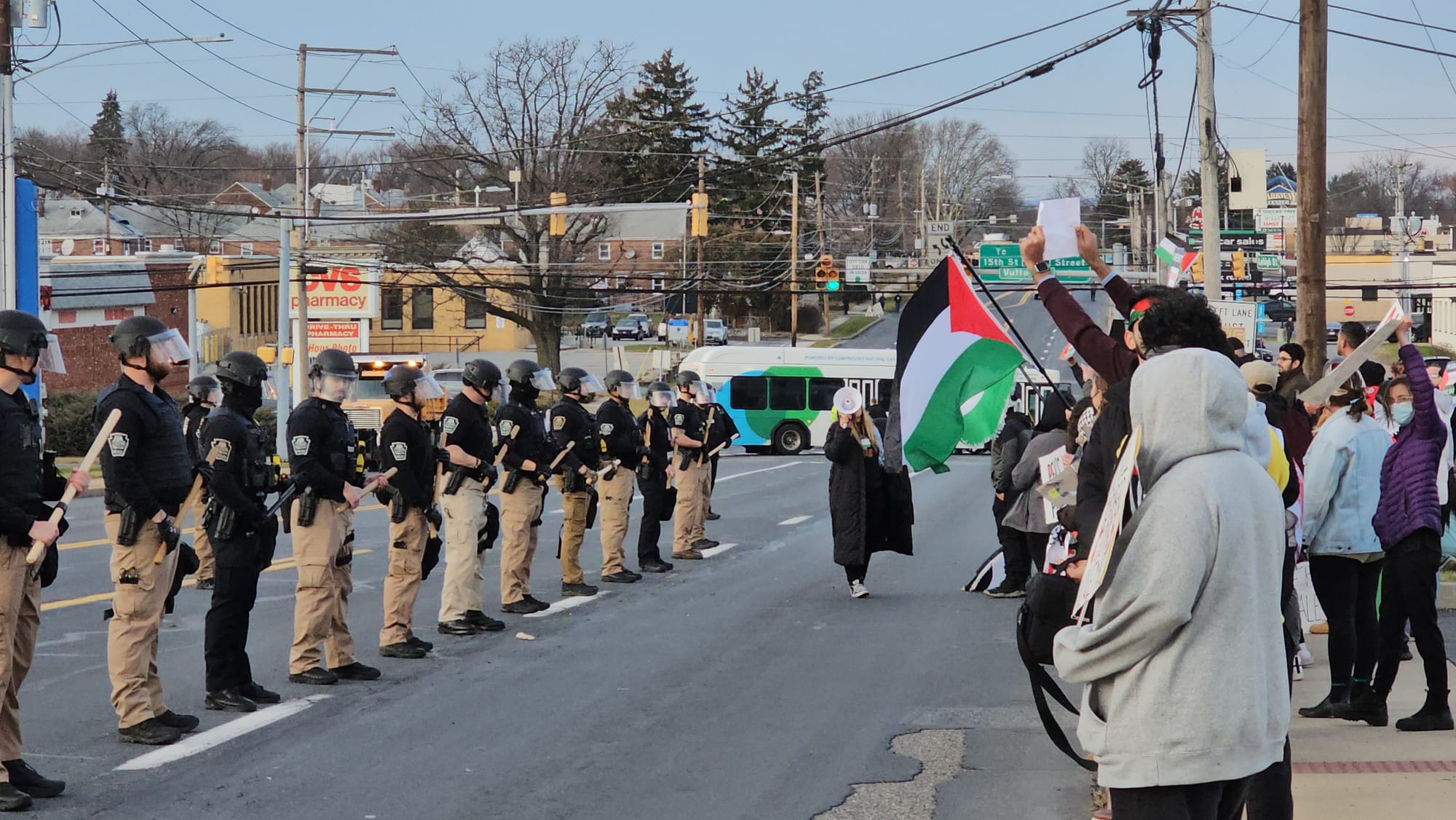 Allentown police equipped with riot gear line Lehigh Street in front of a group of pro-Palestine protestors ahead of Presiden