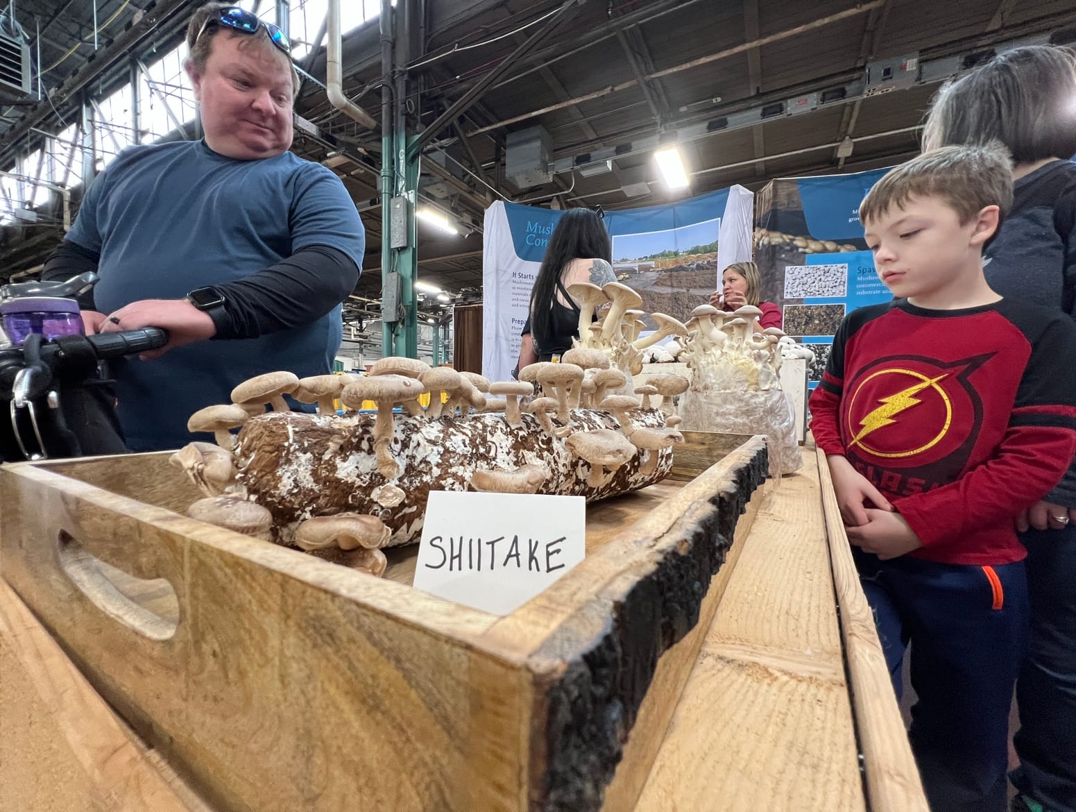 Child looks at shiitake mushrooms at the 2023 Pennsylvania Farm Show.