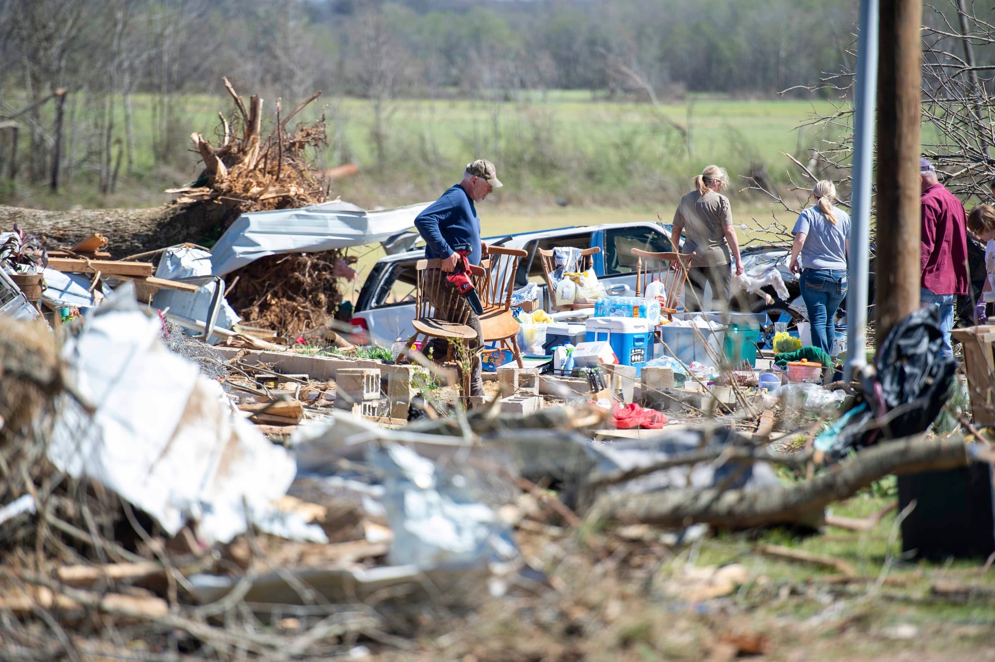 A family moves furniture out of their destroyed home in Adamsville, Tenn. on Saturday, April 1, 2023. A series of storms swep