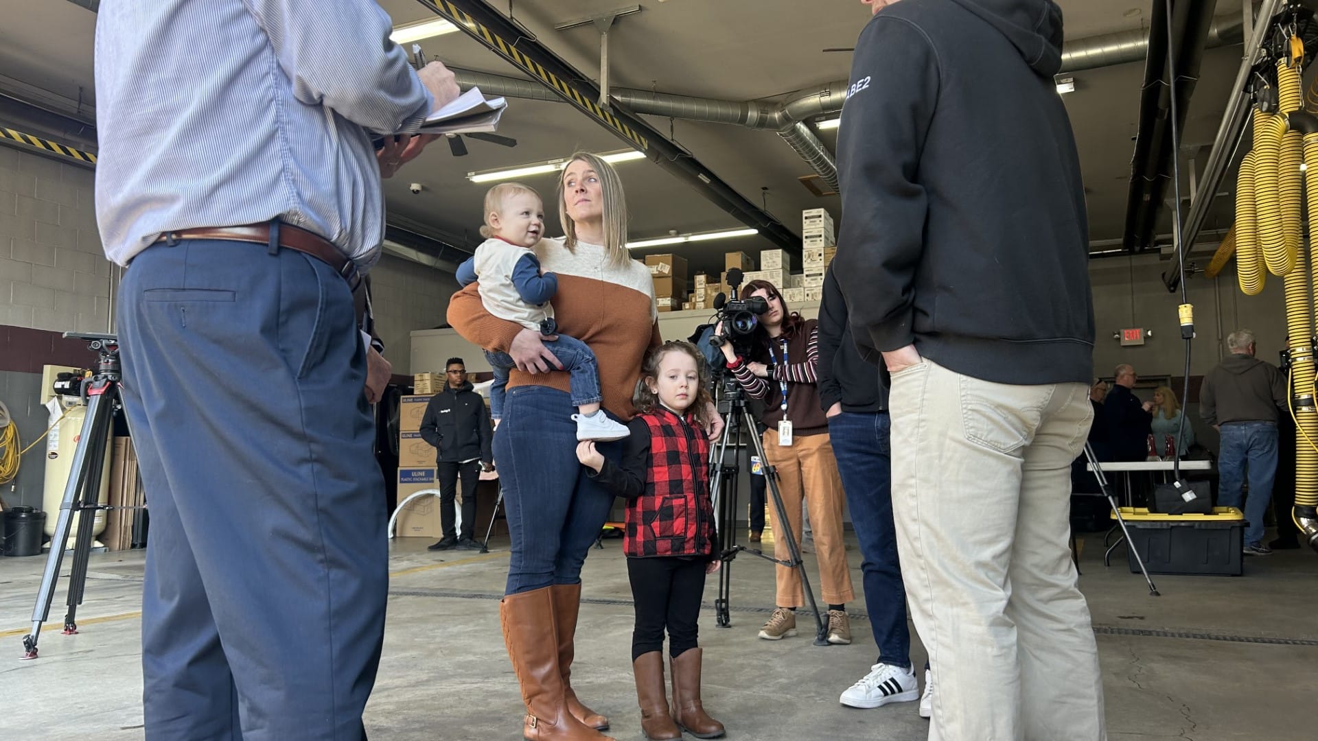 Katie Young and her children, Ada and Holden, thanking the team of EMS, fire, and medical professionals that helped to save h