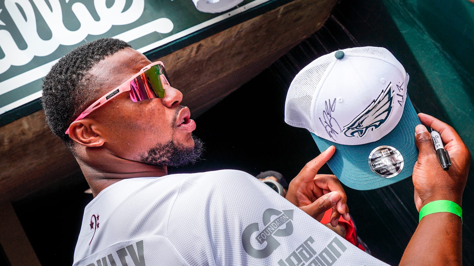 Saquon Barkley shows his new teams' hat. The annual DeVonta Smith Celebrity Softball Game featuring Philadelphia Eagles and o