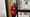 Amy Austin, a woman standing in a doorway wearing a red sweater and black pants
