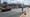 A man stands in a crosswalk as a car drives past him