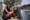 A Taliban fighter holds a machine gun in front of the main gate leading to the Afghan presidential palace on Monday in Kabul. The U.S. struggled to manage a chaotic evacuation afte...