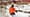 A skier on top of a slope wearing a red jacket and black hat